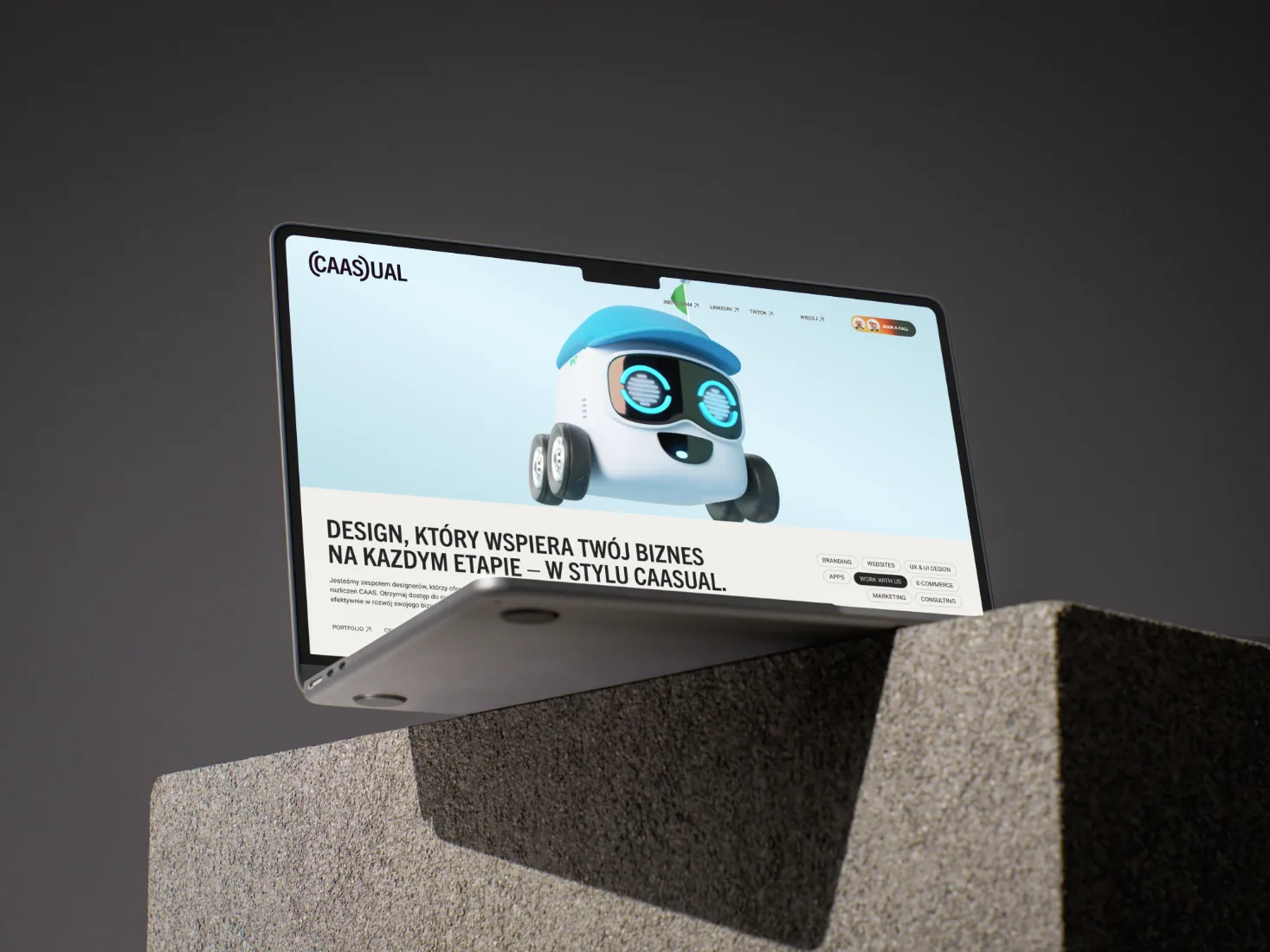 Website-Design von CAASUAL auf einem Laptop mit einem Roboter-Maskottchen in 3D