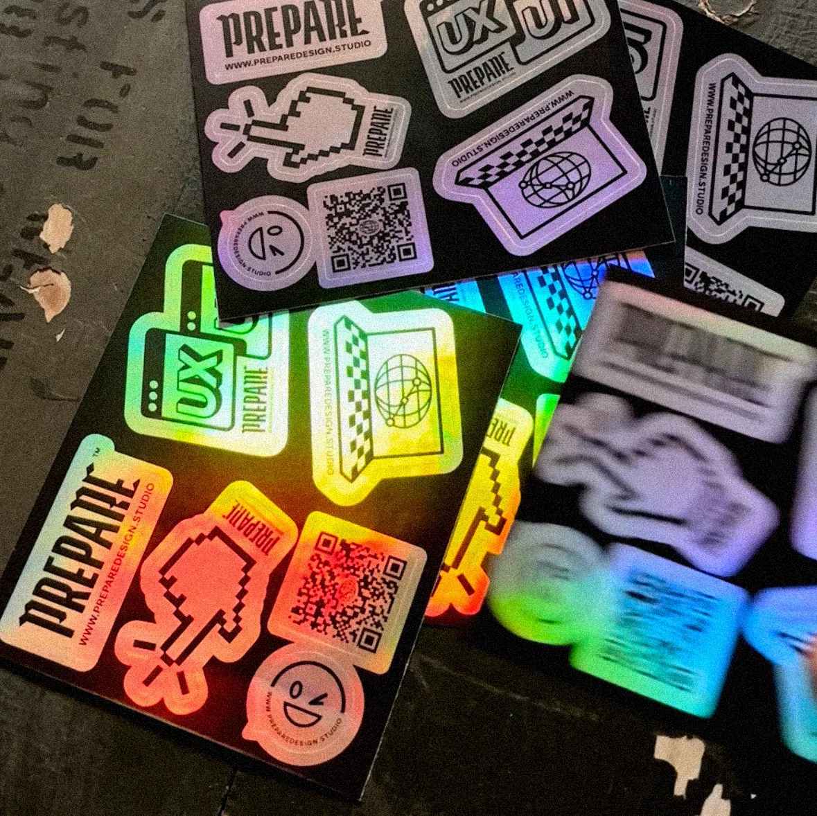 Holografische Stickerbögen von PREPARE Design studio mit Pixel-Cursor, UX-Icon und QR-Code