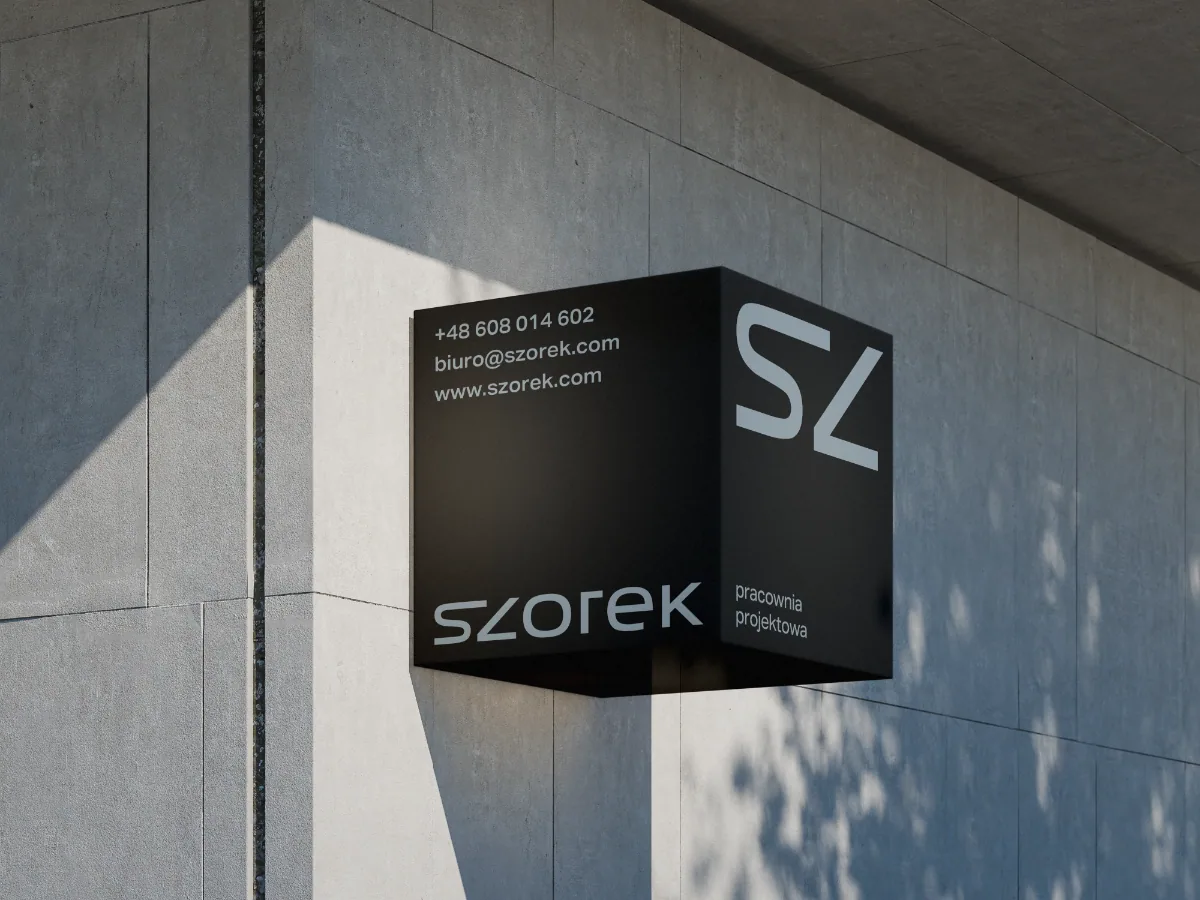 Schwarzes würfelförmiges Wandschild von SZOREK mit Logo und SZ-Monogramm am Architekturbüro